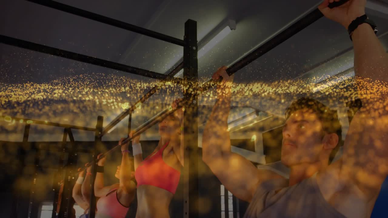 Group gripping bars, starting pull-ups while golden overlay sweeping over group for fitness class