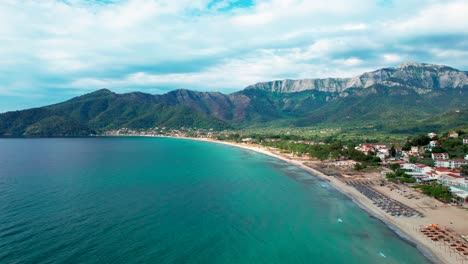 Top-Down-View-Of-Golden-Beach-With-Towering-Mountain-Peaks,-Beautiful-Beachfront-And-Lush-Vegetation,-Thassos-Island,-Greece,-Europe