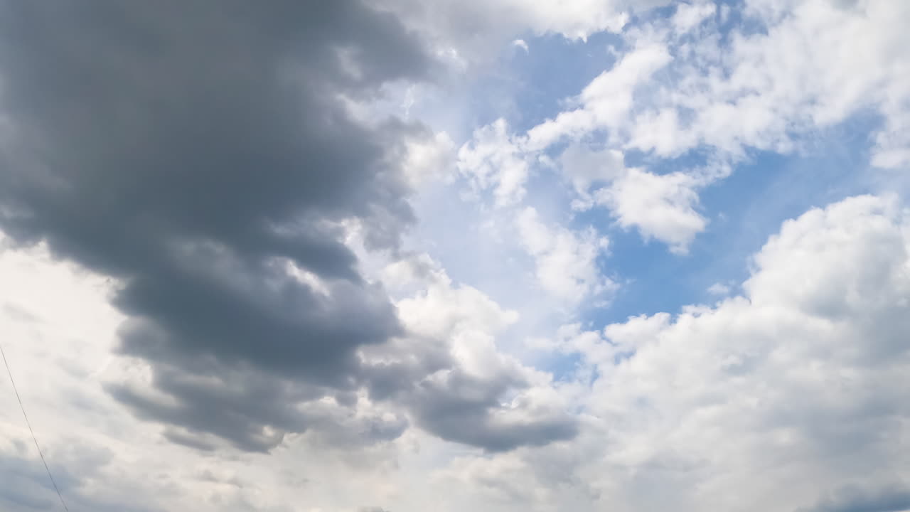 Grey stormy clouds forming in the atmosphere. Sun is hidden behind the cloudscape. Timelapse.