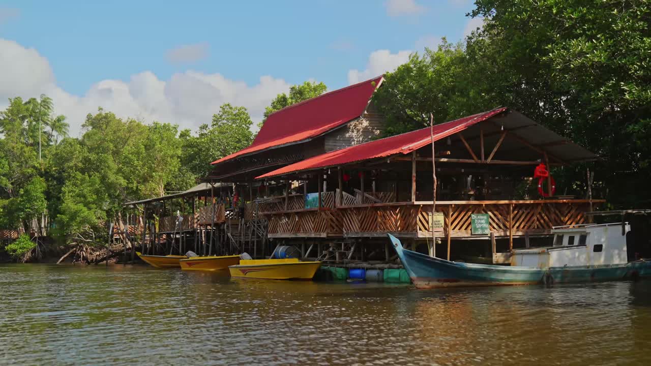 viajando a lo largo del río hacia algunas viviendas locales en pilotes en la isla de bintan, islas riau, indonesia