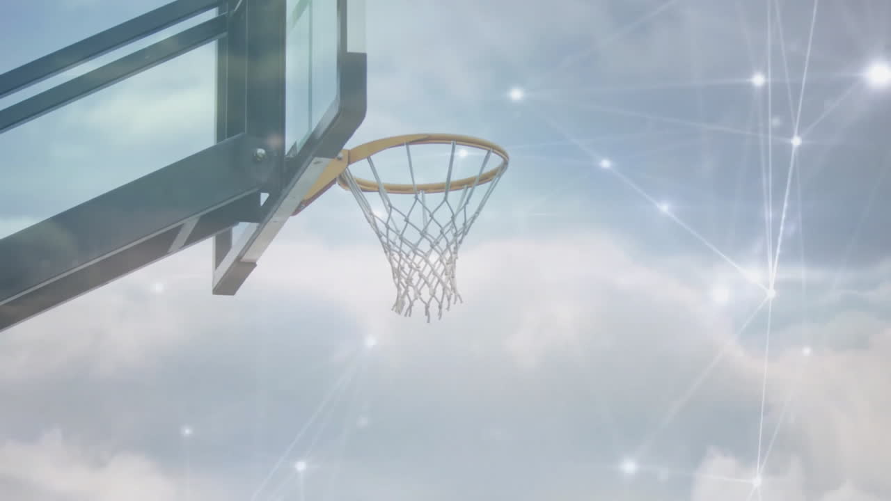 Basketball hoop with digital network animation over cloudy sky background