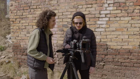 two production co workers talking and setting up a camera in the street