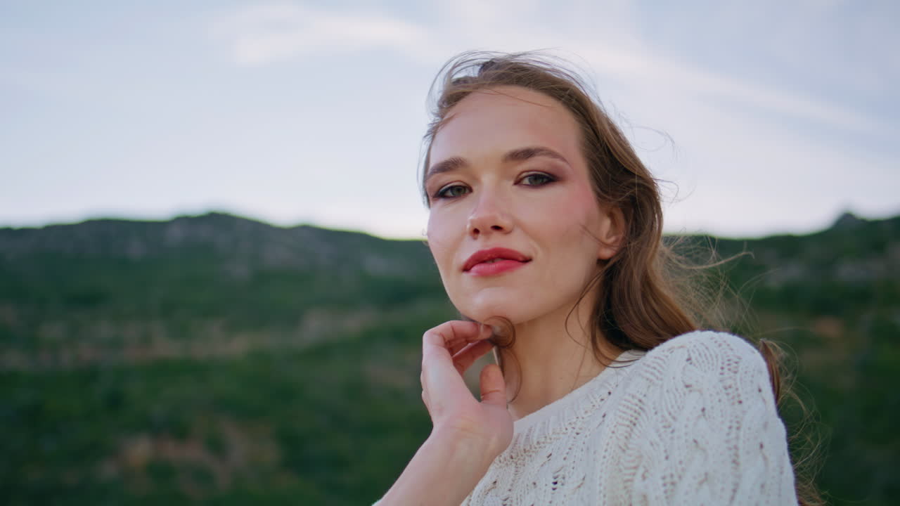 Portrait tourist standing evening nature touching hair. Relaxed woman posing