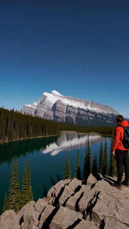 hiker admiring a stunning mountain and lake landscape