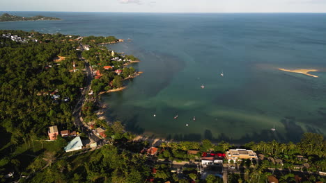 aerial-view-of-Koh-Samui-south-east-asia-travel-holiday-destination-drone-fly-above-Thailand-scenic-tropical-paradise-beach-seascape-at-sunset-revealing-coastline