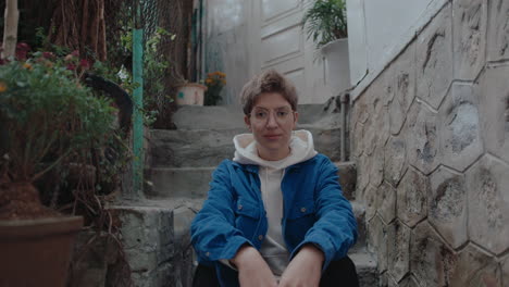 young woman sitting on staircase posing on camera
