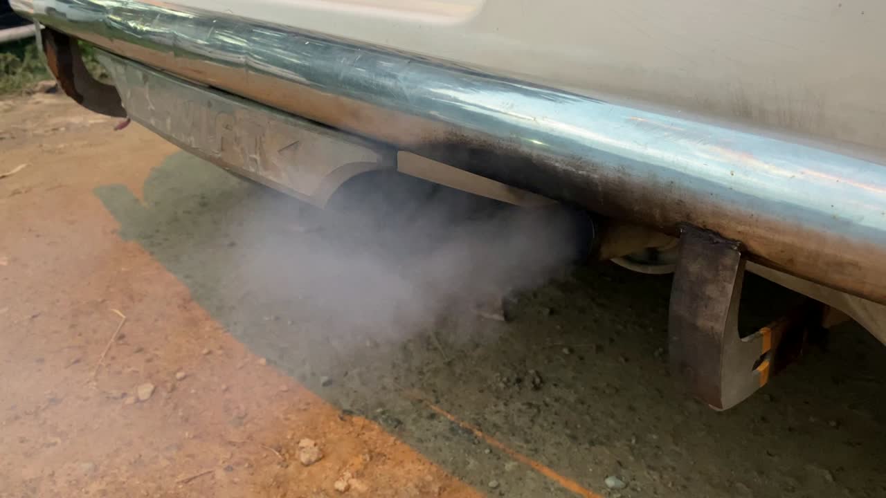 검은 배기가스 연기. 자동차 엔진 흡연. 흡연 배기가스 파이프, 클로즈업. 가솔린 또는 디젤 엔진을 가진 자동차. 겨울 시즌에 오일에서 엔진을 따뜻하게하는 것.