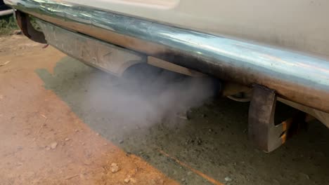 black exhaust smoke. car engine smoking. smoking exhaust pipe, closeup. car with gasoline or diesel engine. engine warming up at idle in winter season