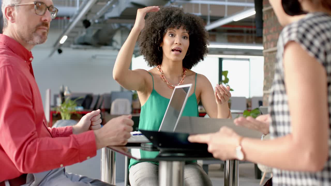Empresária afro-americana discutindo com a equipe de colegas no escritório.