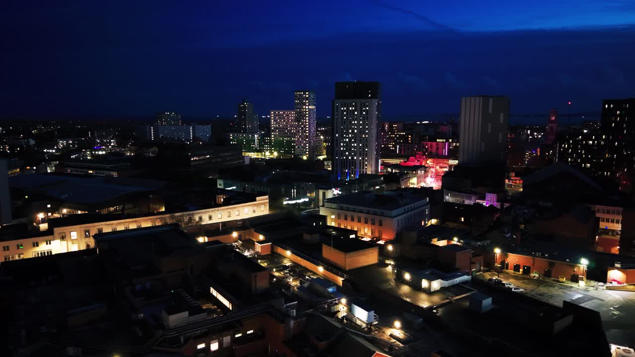 Veduta aerea con drone del centro di Portsmouth di notte, con edifici, strade e torri residenziali illuminati nell'Hampshire, sulla costa meridionale dell'Inghilterra