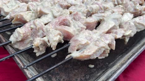 raw chicken kebab pieces strung in skewers prior to roasting.
