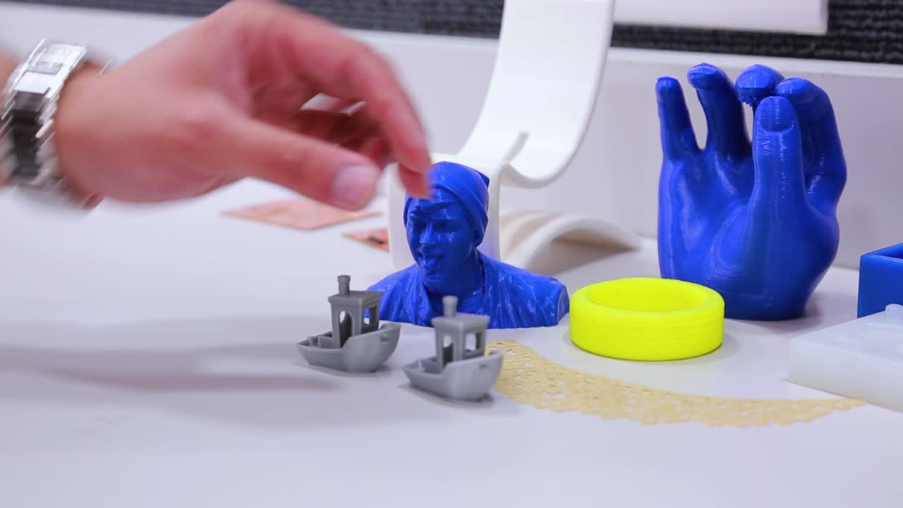 formas impresas en 3d en diferentes colores, azul, amarillo, plateado y blanco.