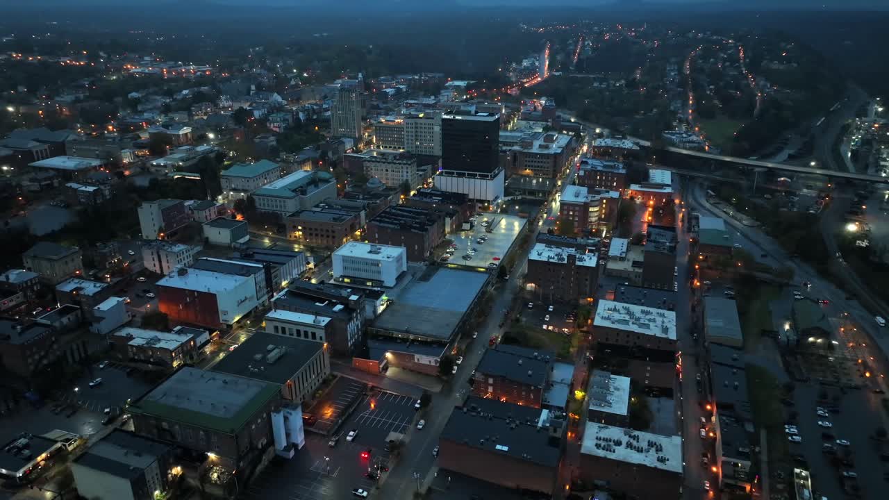 Aerial view of lighting american town with blocks and towers at night. Rainy day in autumn season. Charming and warm Lighting streetlights. Top Down.Virginia, USA.