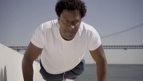 front view of confident young man listening music during workout.