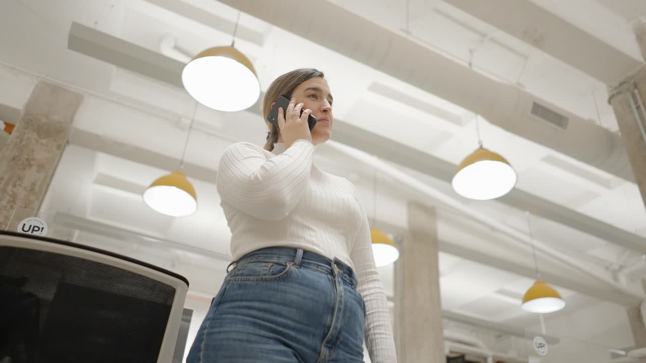 mujer hablando por teléfono en una oficina moderna