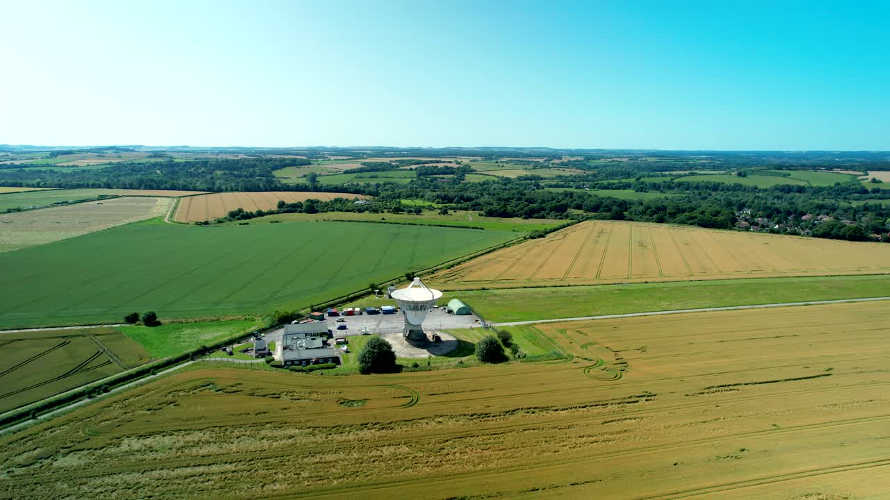 Osservatorio di Chilbolton, array di antenne radiotelescopiche per astronomia, orbita aerea a sinistra sopra un campo coltivato.