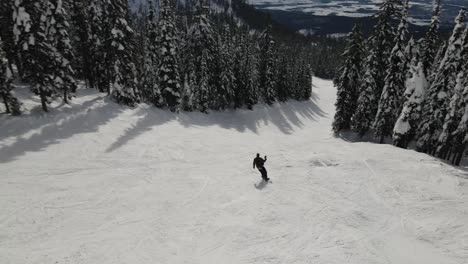el snowboard aéreo sigue el movimiento desde un ángulo alto con la hermosa montana en el fondo