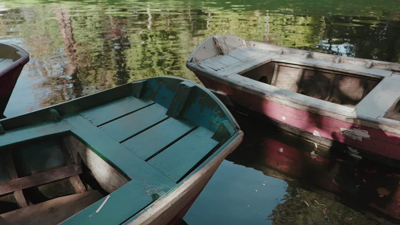오래된 나무 보트들이 브라가의 봄 제수스 호수의 잔잔하고 반사되는 물 위에 놓여 있어요