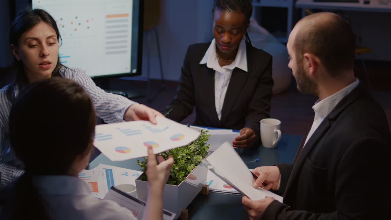 Diverse multi ethnic businesspeople sharing management presentation on paperwork