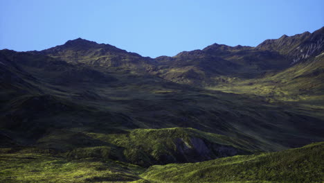 serene green mountains under clear blue sky in a remote location