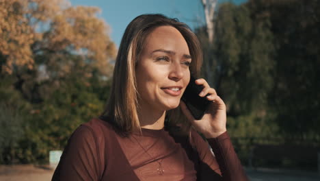 una mujer joven usando un teléfono inteligente al aire libre.