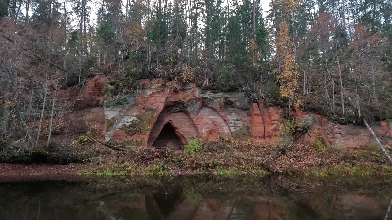 cueva de los ángeles, un acantilado de arenisca roja en forma de alas de ángel, en el río salaca en el parque natural skanaiskalns en mazsalaca, letonia, tiempo de otoño