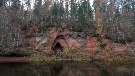 Cueva-De-Los-ángeles,-Un-Acantilado-De-Arenisca-Roja-En-Forma-De-Alas-De-ángel,-En-El-Río-Salaca-En-El-Parque-Natural-Skanaiskalns-En-Mazsalaca,-Letonia,-Tiempo-De-Otoño