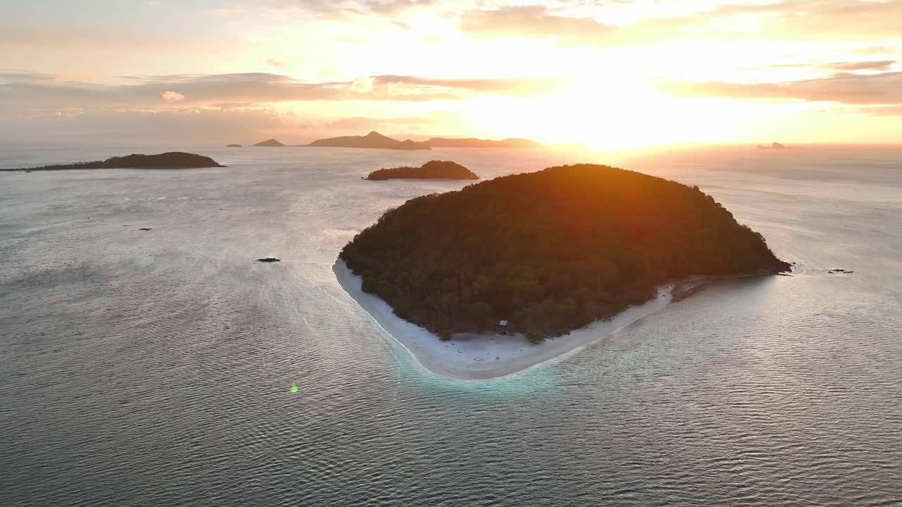 Rising aerial shot of Cagdanao Island, with beautiful sunset in the horizon, in Philippines