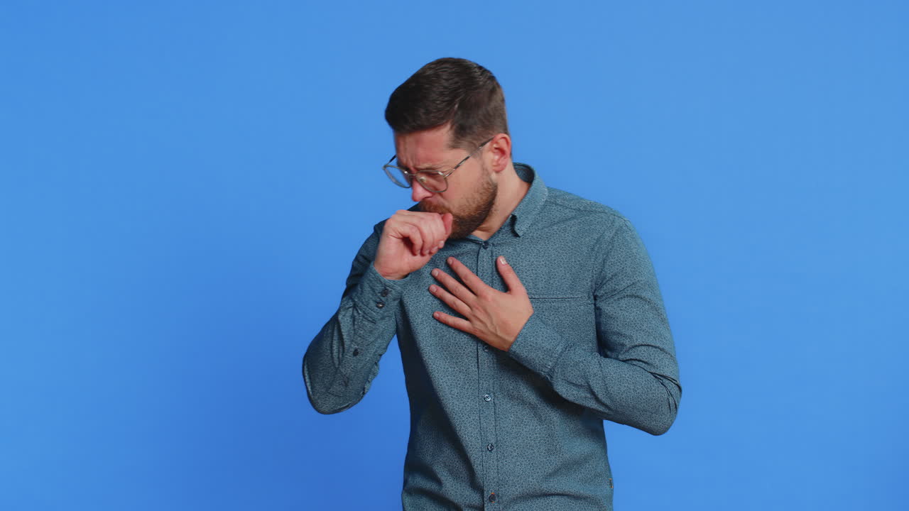 Unhealthy ill man coughing with seasonal flu symptoms sick allergy fever or viral infection