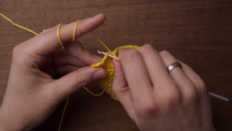 primer plano superior de manos caucásicas haciendo algunos trabajos con agujas: crochet