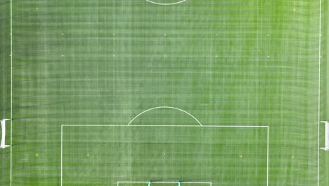 an aerial view of a neatly maintained soccer field with visible white boundary lines and goalposts at each end