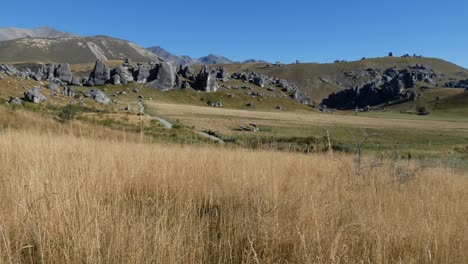 Wide-view-from-summertime-golden-grass-of-amazing-limestone-rock-formations-at-Castle-Hill-Conservation-Area,-New-Zealand