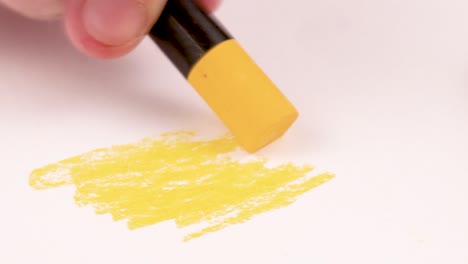 drawing with a yellow crayon on a piece of paper