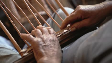 old man working with wicker close up shot