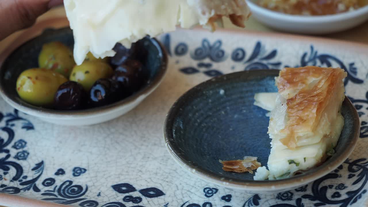 Hand holding fork with a bite of pastry