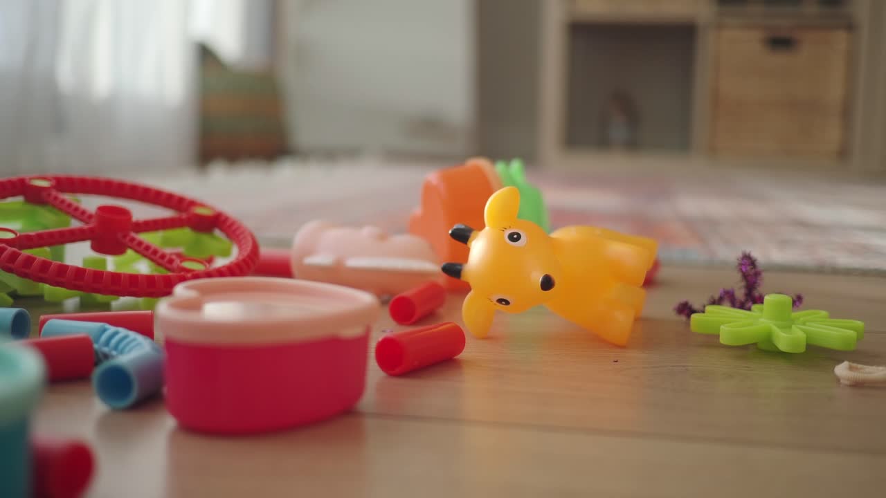 Colorful Children's Plastic Toys Scattered on a Wooden Floor