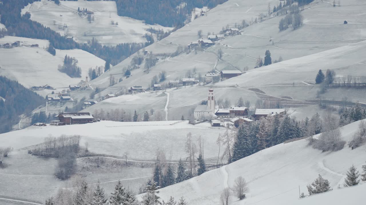 Gentle slopes covered in snow surround remote alpine villages in South Tirol.