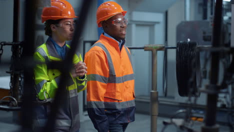 ingenieros sonrientes caminando fábrica tecnológica moderna discutiendo proyecto