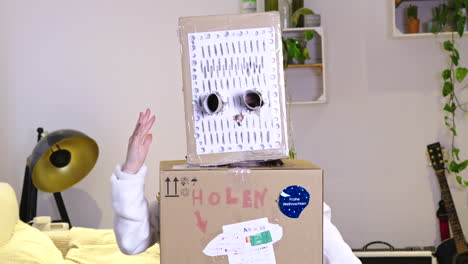 un niño baila alegremente con un disfraz de robot casero hecho de cartón y papel. el telón de fondo es una acogedora sala de estar con una lámpara moderna, guitarra y plantas que añaden a la atmósfera lúdica.