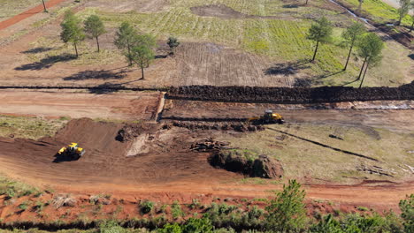 heavy machinery flattens the ground from above at an active construction zone