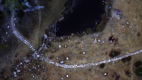 Aerial-drone-top-view-of-the-tranquil-Butterfly-Lake-and-a-stone-path-in-the-Uinta-National-Forest-in-Utah-on-a-foggy-summer-morning-while-camping