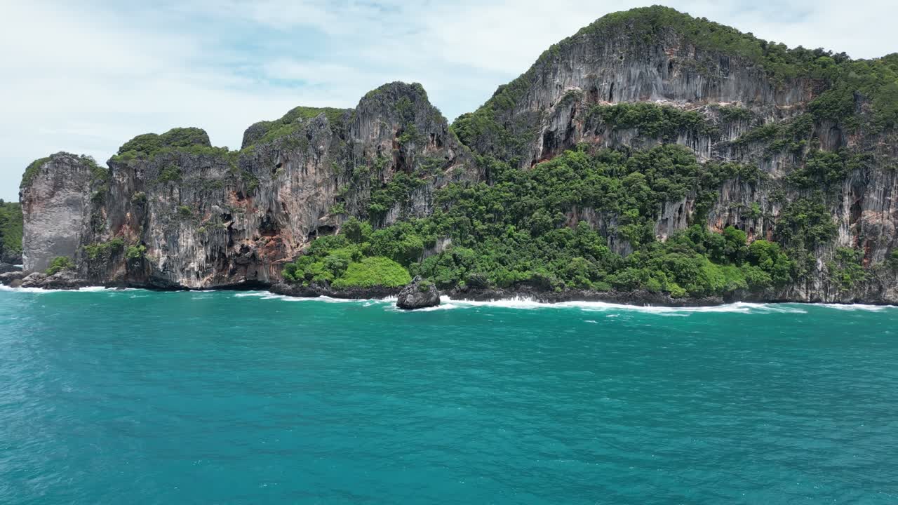 A sweeping aerial panning dolly capturing the dramatic cliffs and island landscapes of Koh Phi Phi, Thailand, with stunning detail.