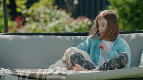 Cute-teen-girl-plays-with-a-golden-retriever-puppy.-Sitting-in-a-garden-swing-in-the-backyard-of-a-house-on-a-clear-sunny-day