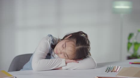 Foto-De-Estudio-De-Una-Chica-Hiperactiva-Aburrida-Sentada-En-La-Mesa-En-Casa-Con-Lápices-De-Colores-2