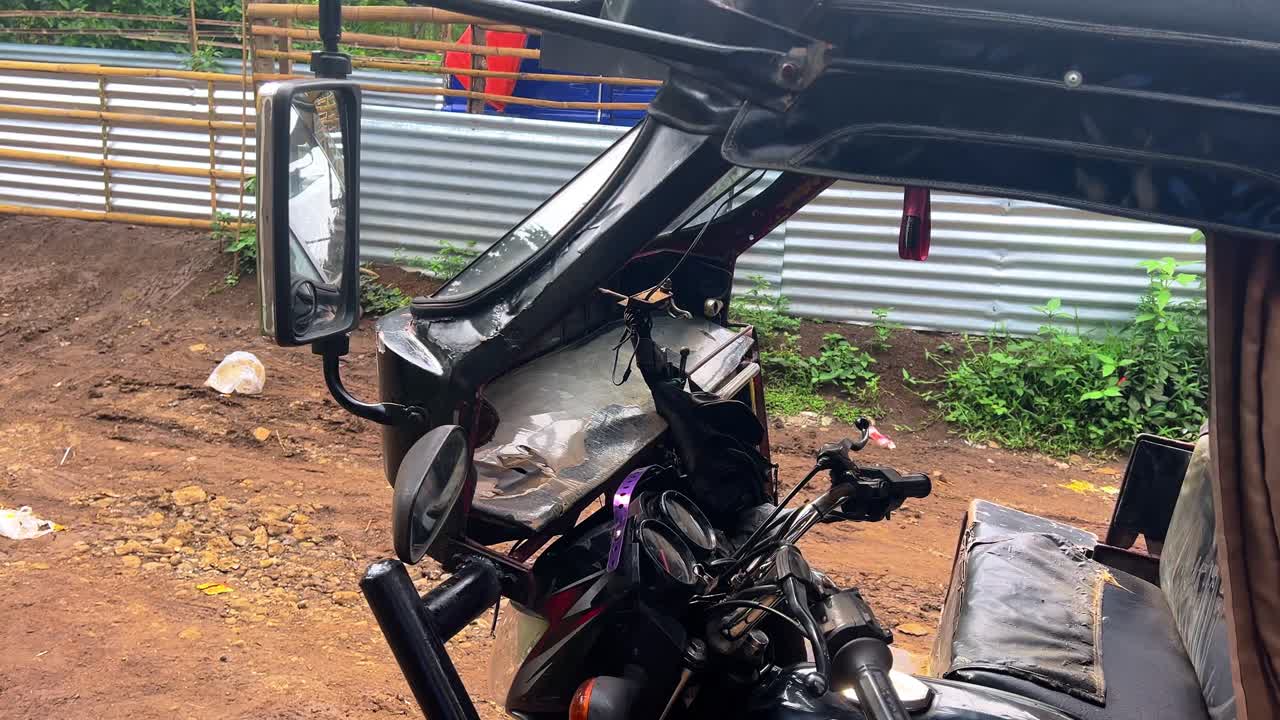 Detailed view of a motorized tricycle rickshaw interior parked on a dirt road, ideal for transportation, travel, and developing country lifestyle projects