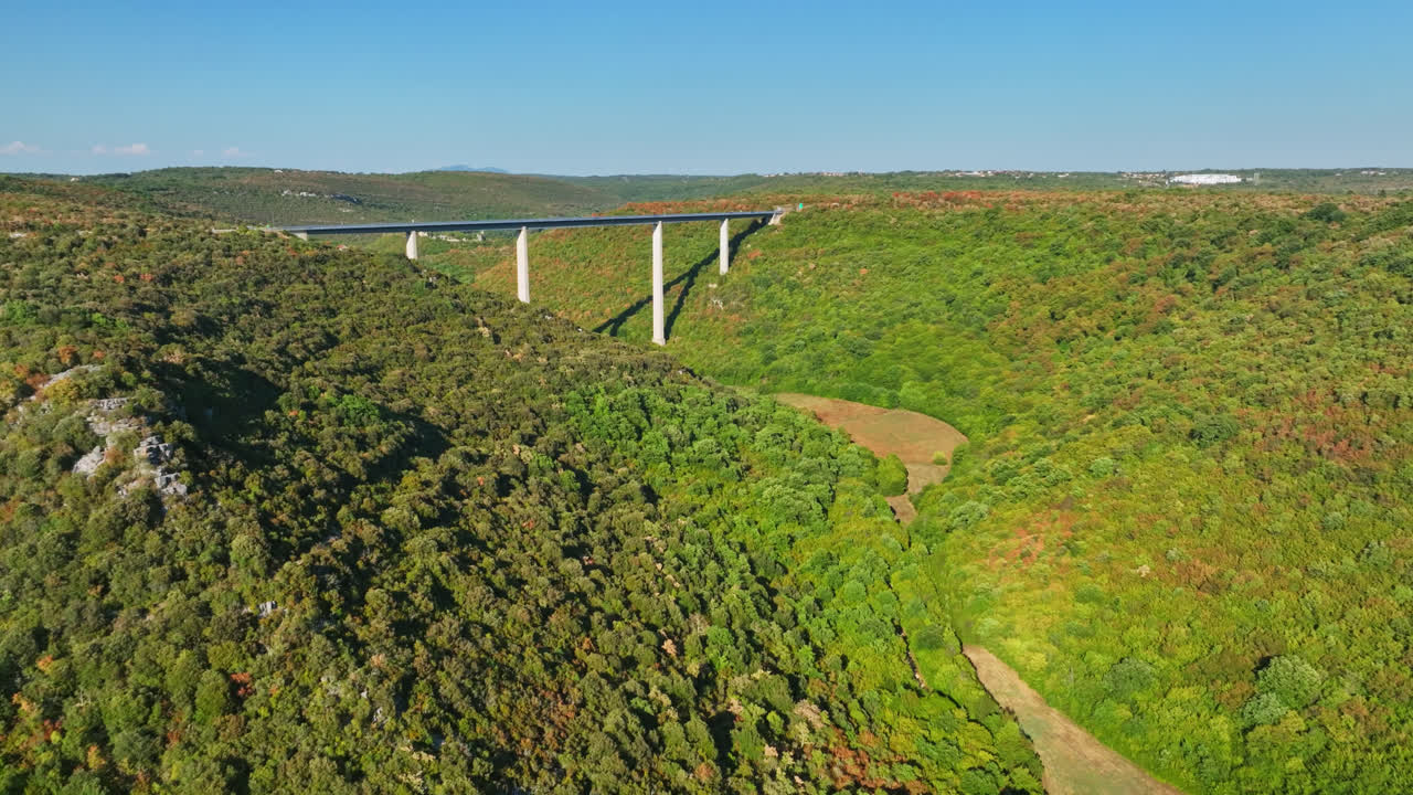 Aerial View of a Long Bridge in a Green Valley