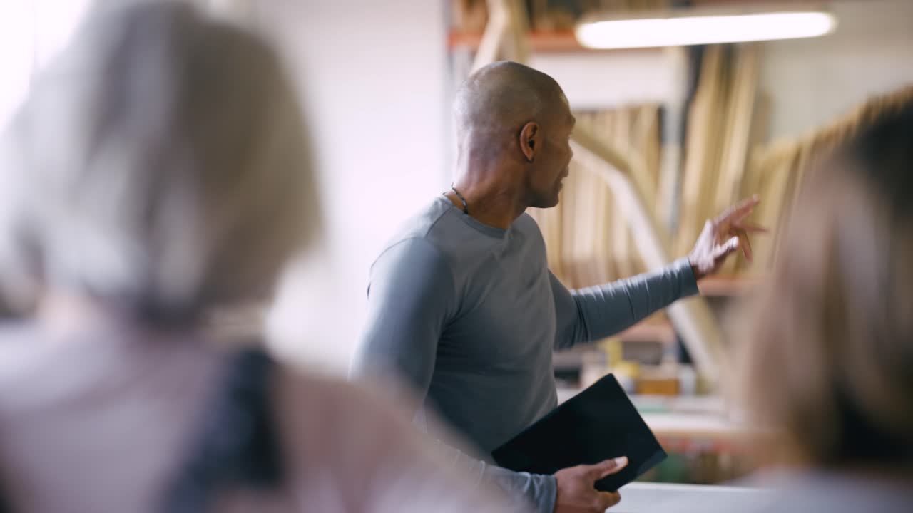 Professional Man Speaking and Gesturing with Tablet in Workshop