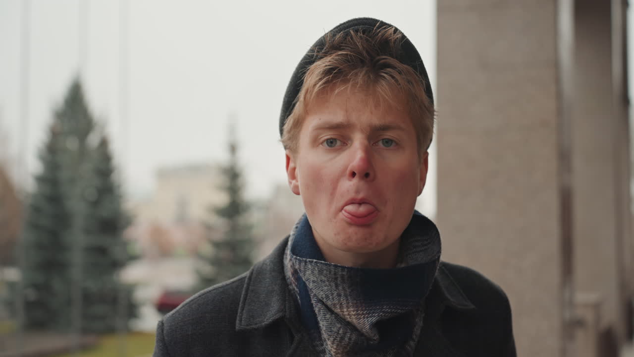 Side profile urban portrait white male creator contemplating cityscape, beanie and scarf, soft snowfall, distant billboard lights, reflective mood of street photographer planning shot