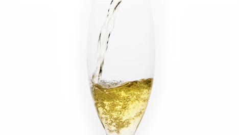 mid shot of white wine poured in slowmotion in a glass