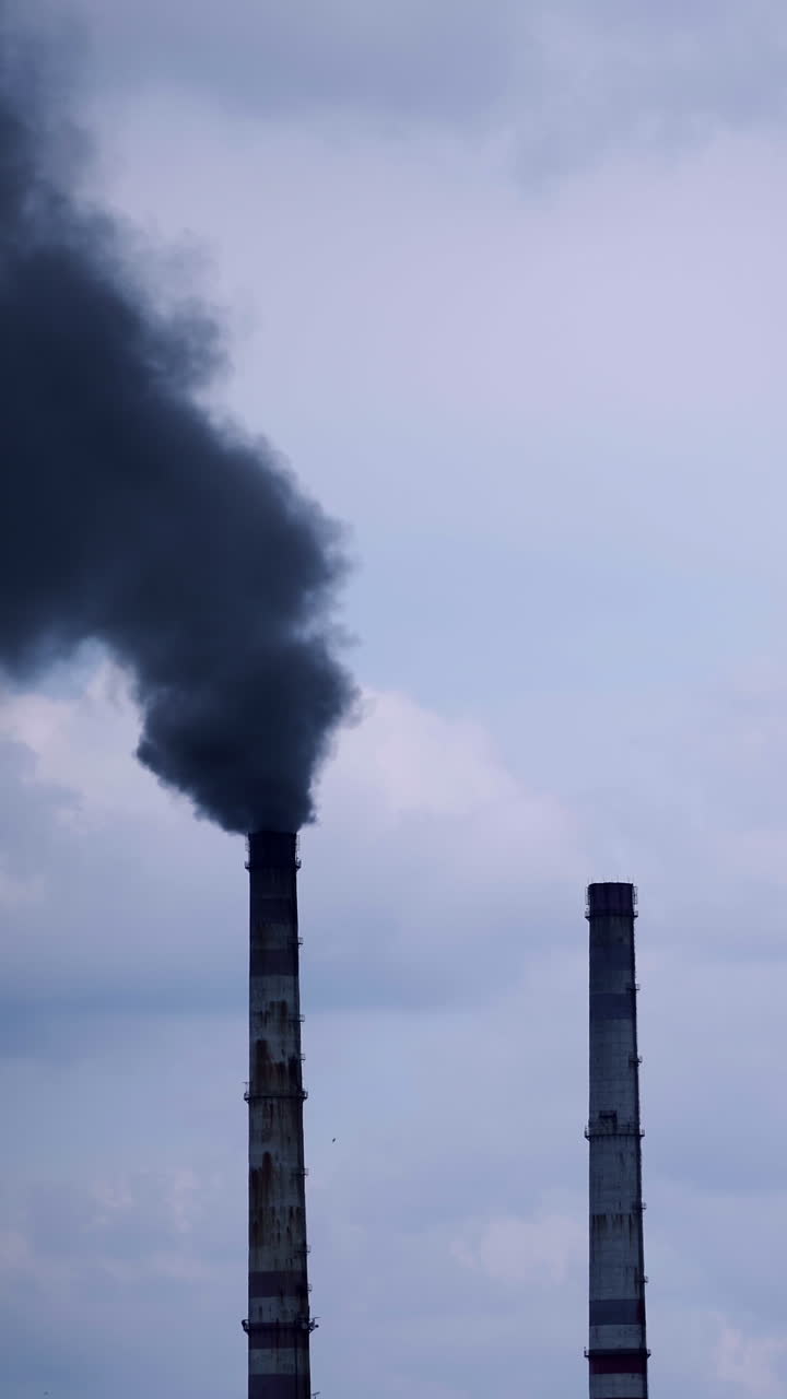 Smoke from industrial chimney. Factory with main chimneys expelling smoke into sky